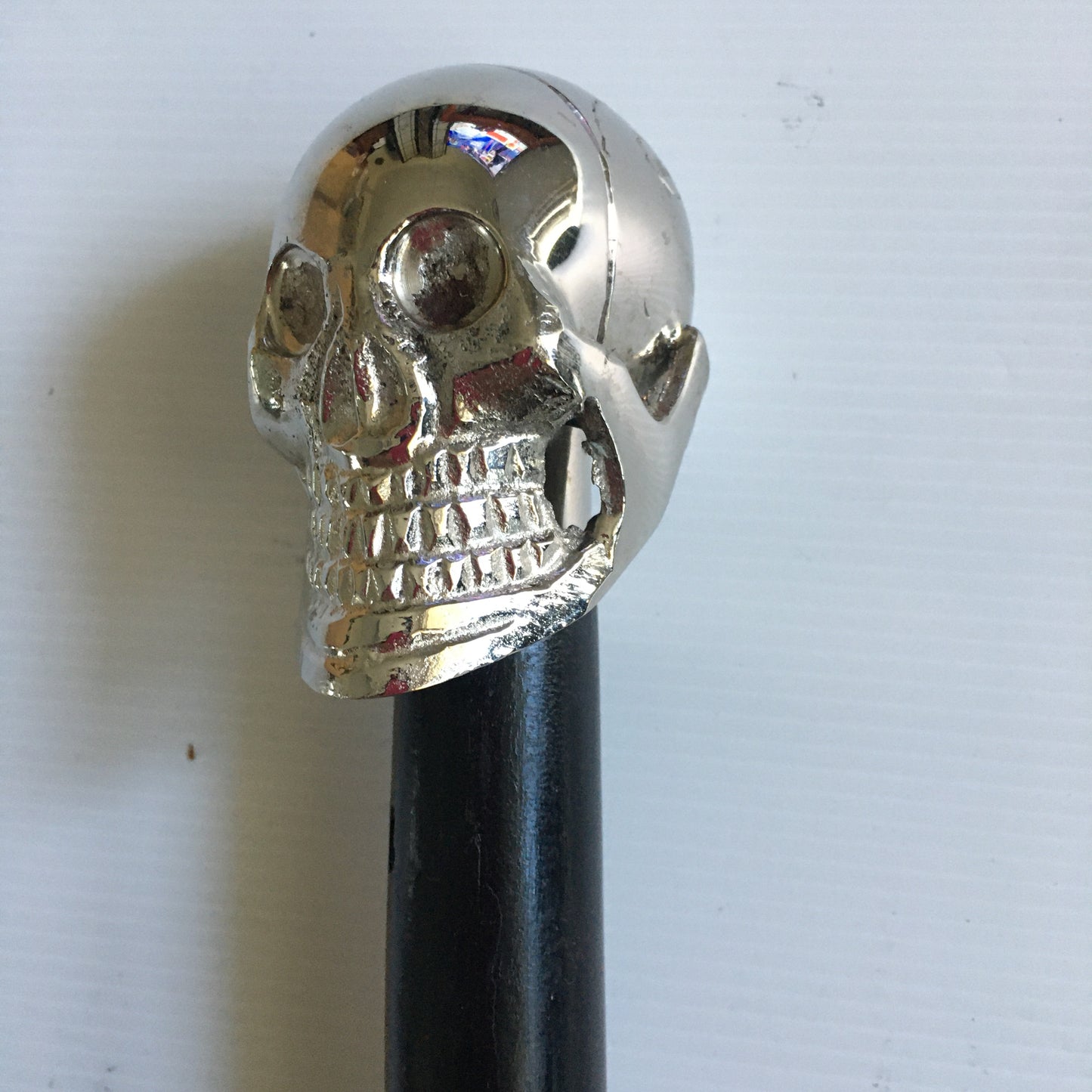 Walking Stick with Silver Skull design Handle on a Plain black stick or turned wood stick.