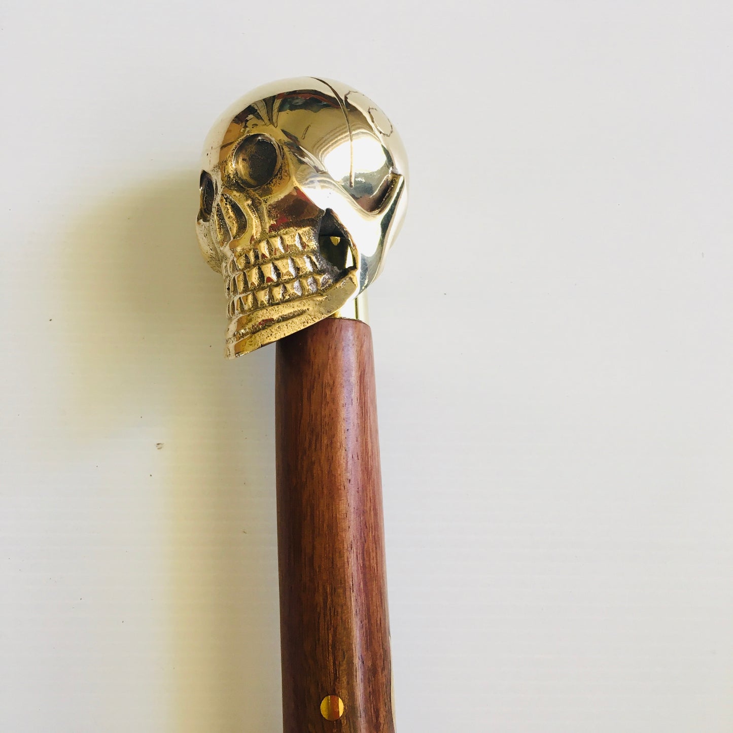 Walking Stick with Shiny Brass Skull Handle on brown inlaid stick