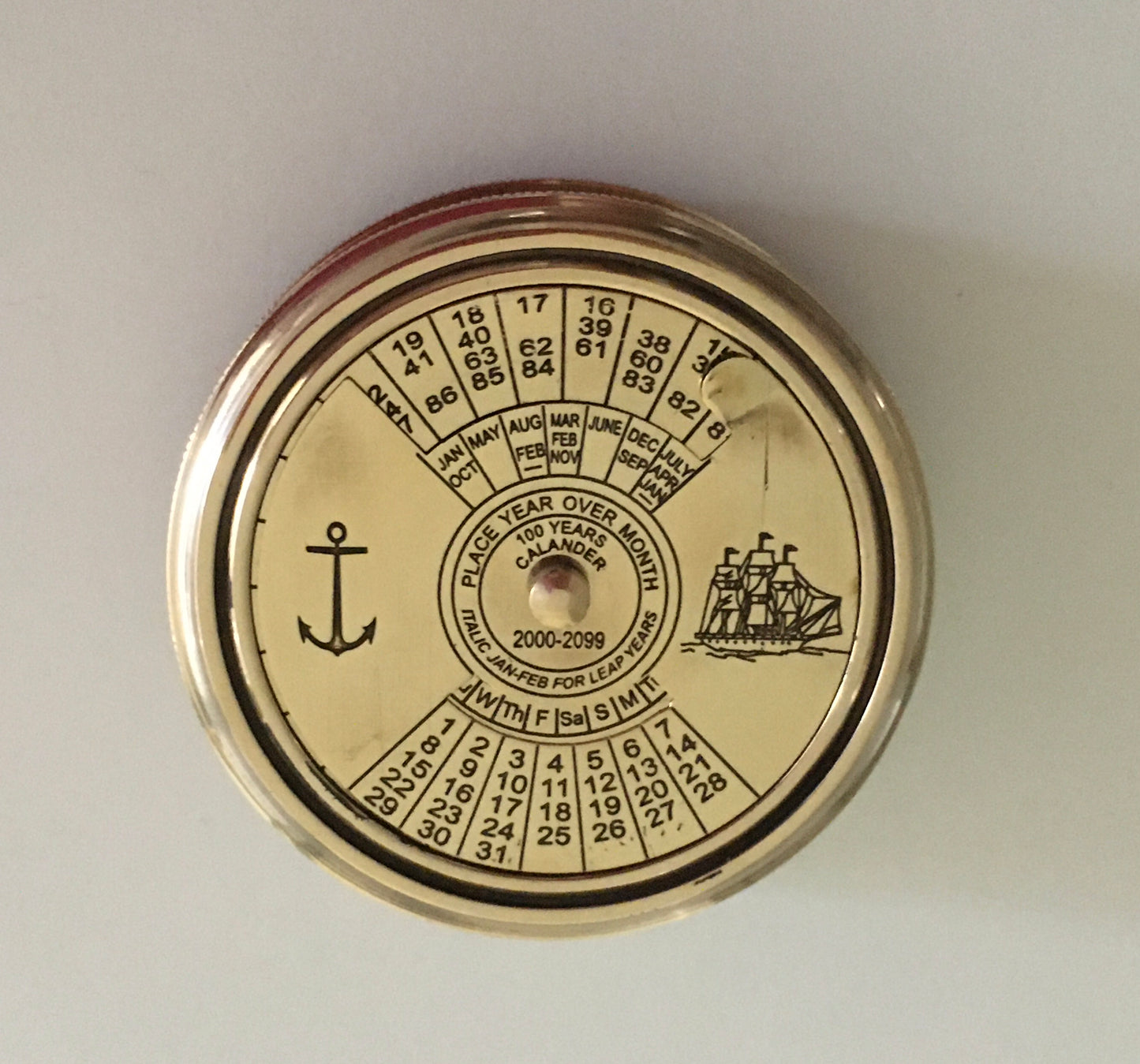 Nautical compass in shiny brass with 100 year calendar