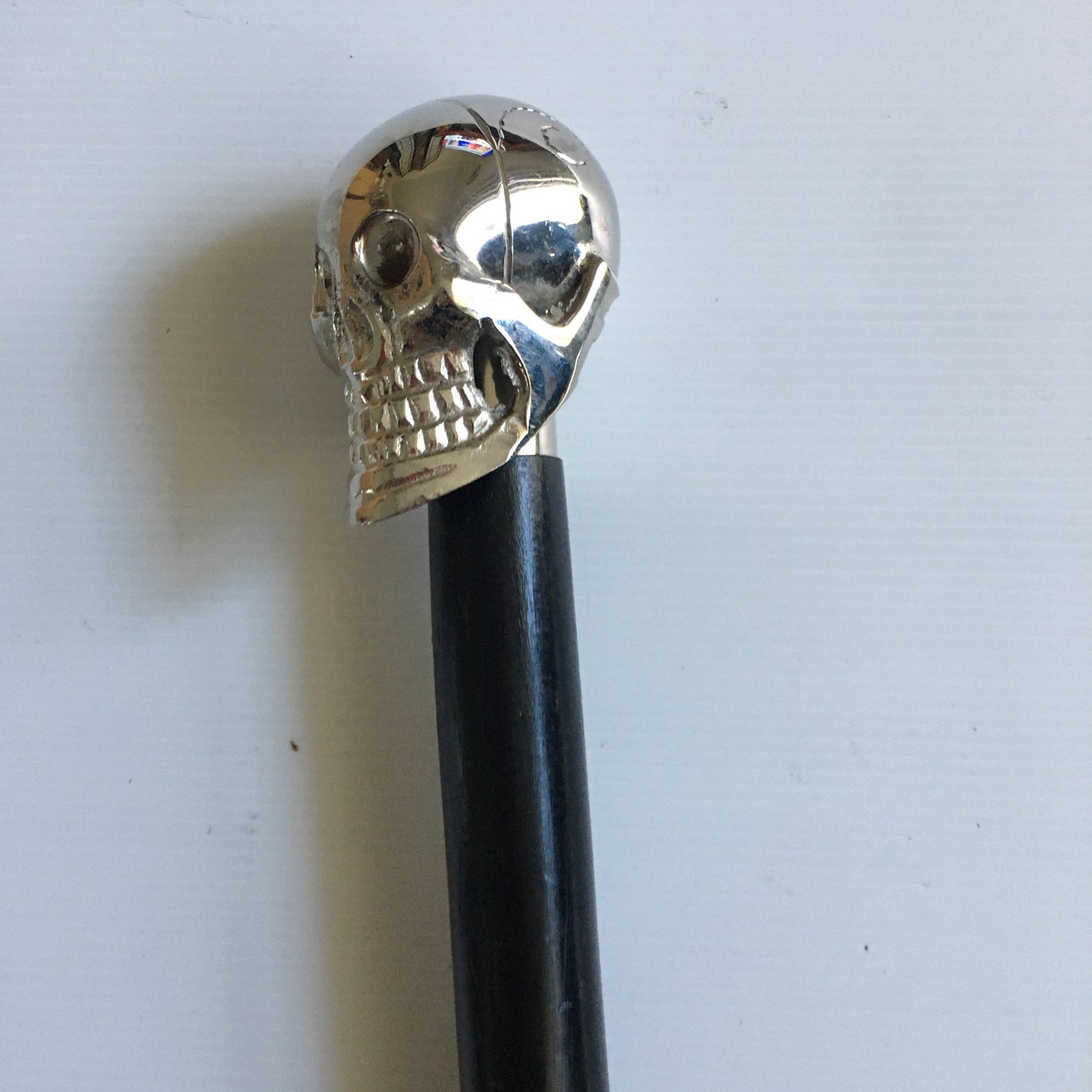 Walking Stick with Silver Skull design Handle on a Plain black stick or turned wood stick.